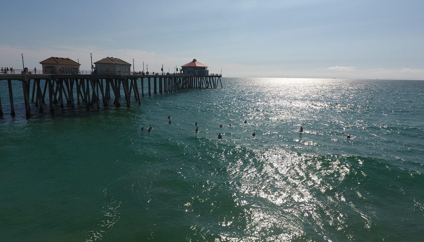 Huntington Beach pier surfers aerial drone shot